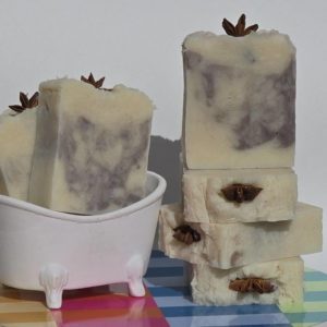 A stack of chichaito soap bars on a table next to a bathtub.`